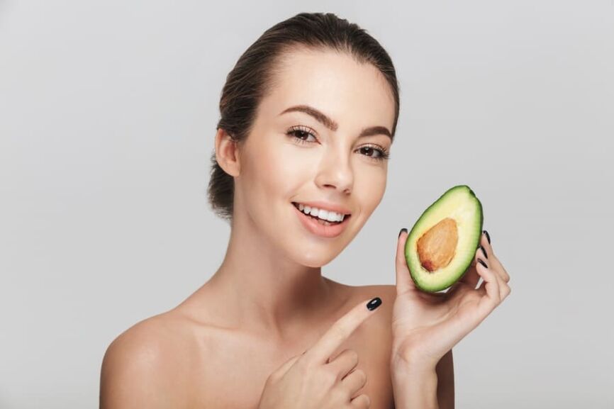 avocado-skin Жена, с хубава кожа, която държи разрязано наполовина авокадо.